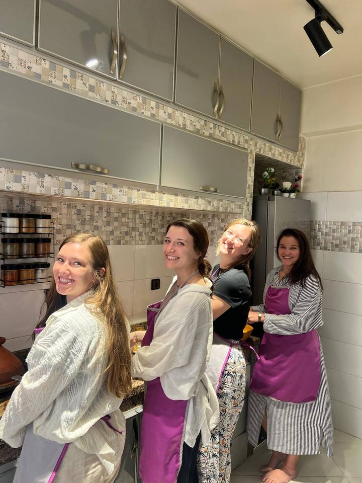Four guests in aprons cooking in the family kitchen