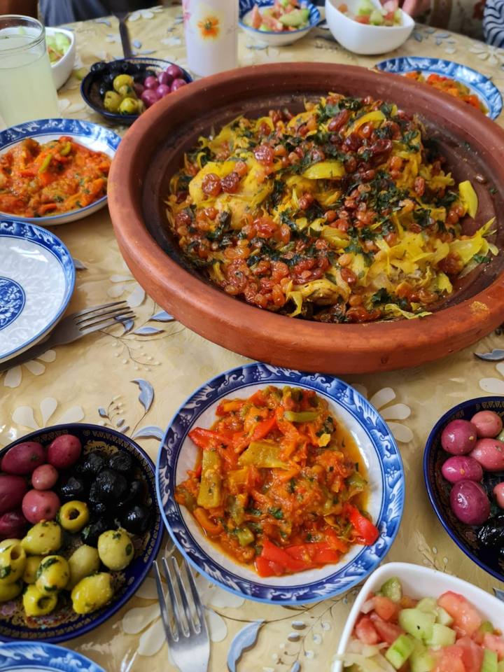 Chicken tagine with olives and cooked salads in painted bowls