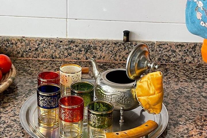 Silver teapot and coloured tea glasses on a tray in the kitchen